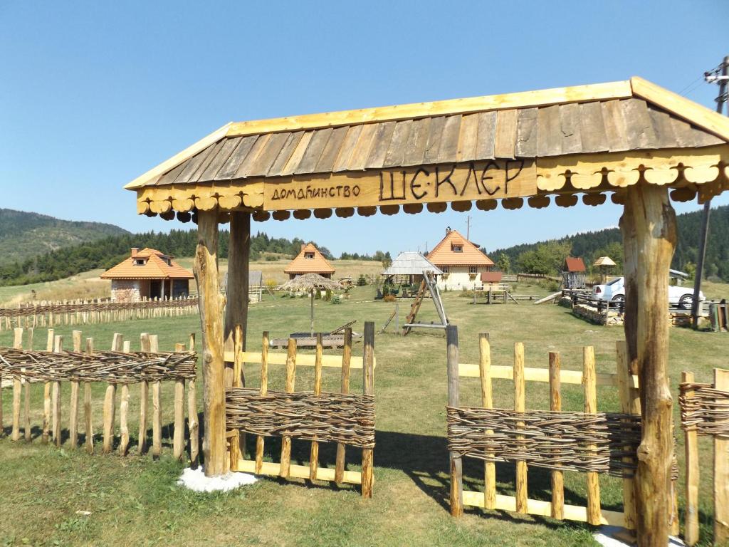 a wooden gazebo with a sign in a field at Apartments Šekler in Rudno