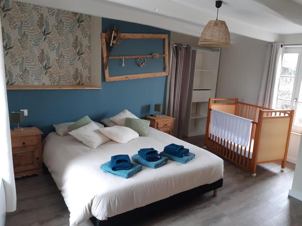 a bedroom with a bed with two blue towels on it at Gite de la perle rouge in Rodelinghem