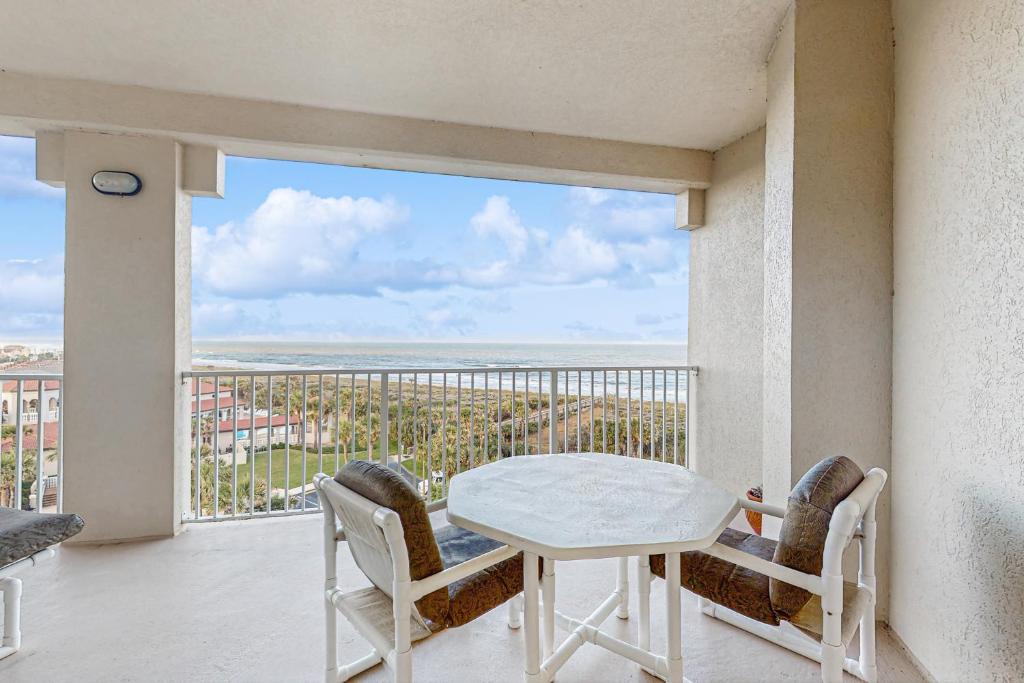 un tavolo e sedie su un balcone con vista sull'oceano di Oceanfront condo & WiFi- snowbirds OK! a Palm Coast