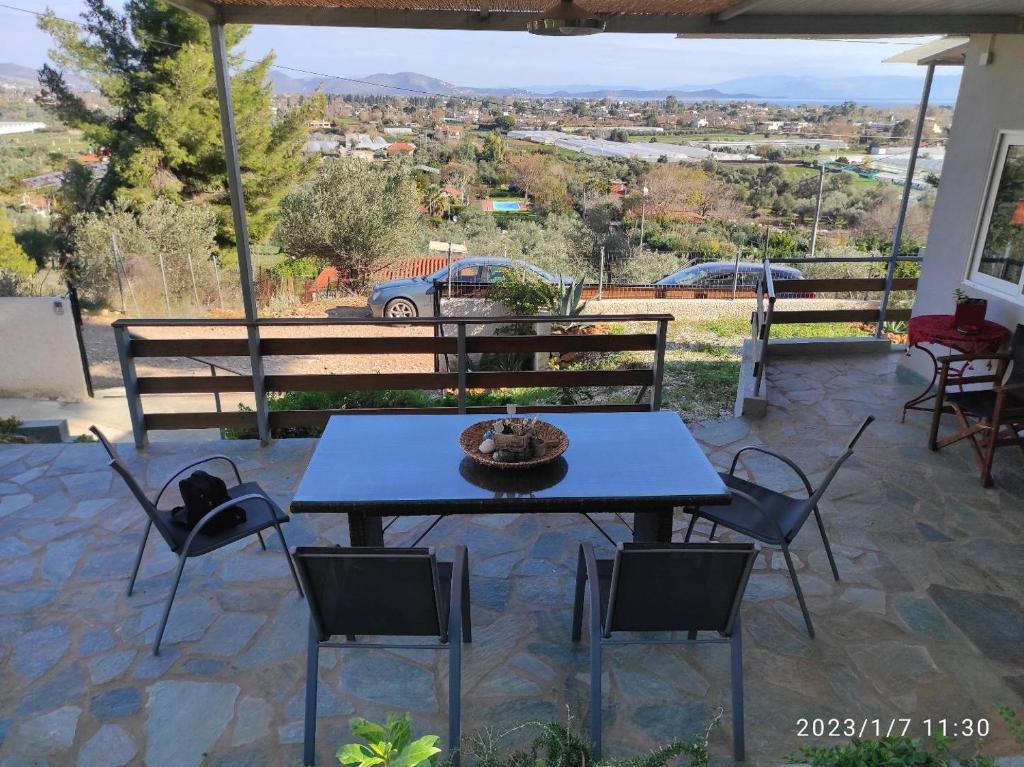 einen blauen Tisch und Stühle auf einer Terrasse mit Aussicht in der Unterkunft Agriliki Cottage - Amazing View & Nature Escape in Vraná