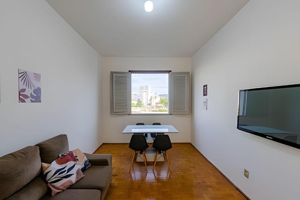ein Wohnzimmer mit Sofa und Tisch in der Unterkunft Estação 3 qtos - Vista cartão postal - BHSH in Belo Horizonte