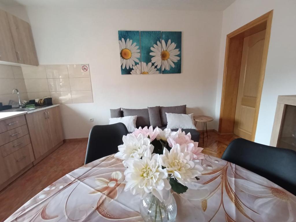 a vase of flowers on a table in a kitchen at Stan na dan Relax in Bosanska Dubica