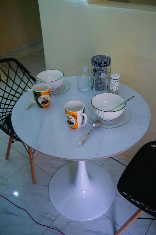 a white table with bowls and cups on it at Monte Homes in Mombasa