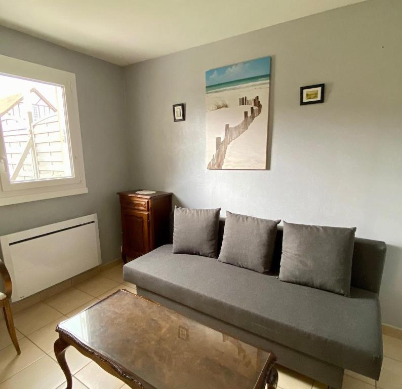 un salon avec un canapé et une table dans l'établissement Appartement 3 pièces cœur Riva Bella, à Ouistreham