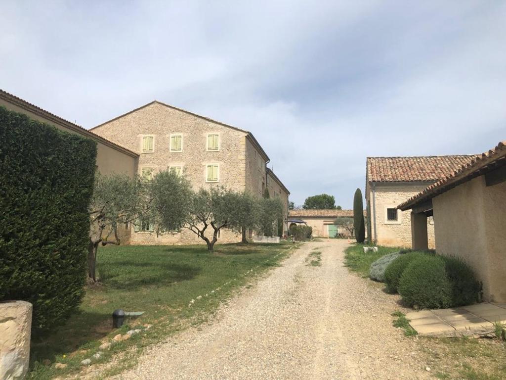 un chemin de terre devant un bâtiment dans l'établissement Studio familial paisible avec piscine au cœur de Valensole - FR-1-822-3, à Brunet
