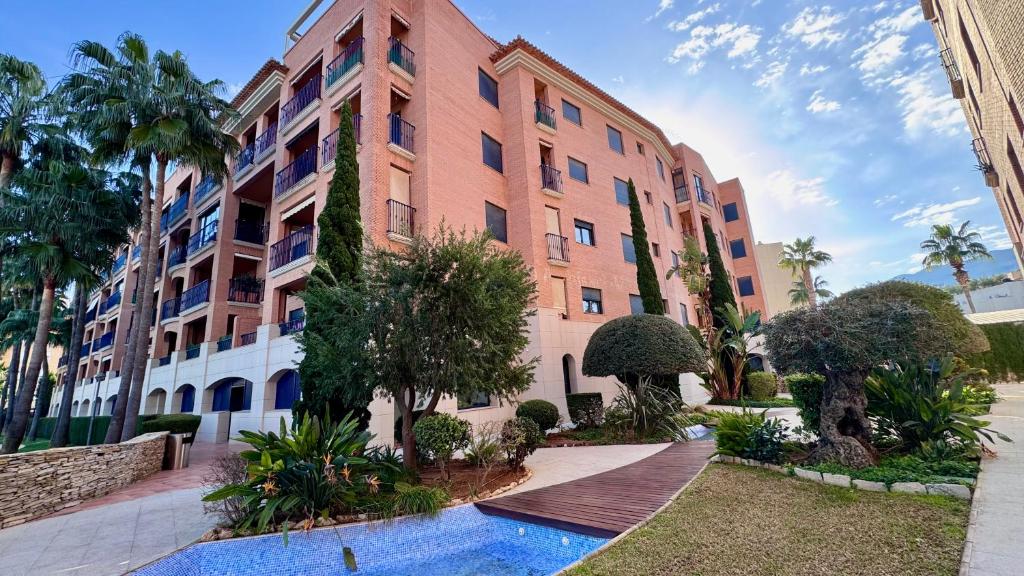 a large building with a swimming pool in front of it at Vilamar VyB in Denia