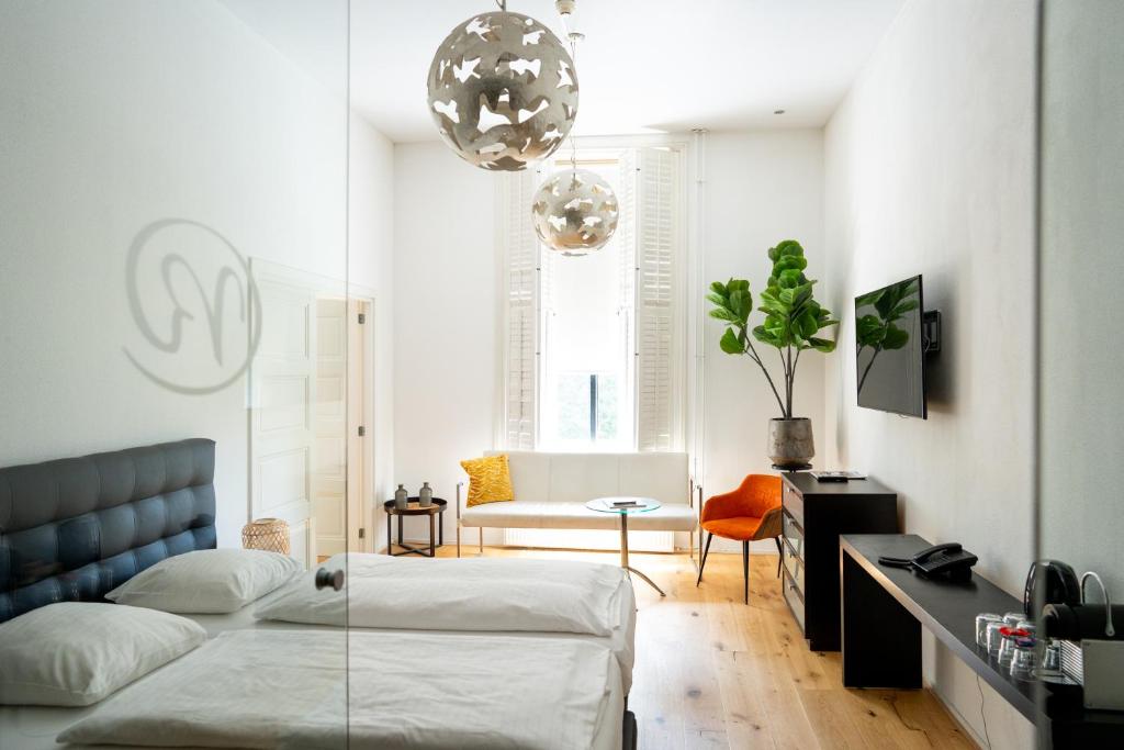 een woonkamer met een bed en een tafel bij Hotel Villa Ruimzicht in Doetinchem