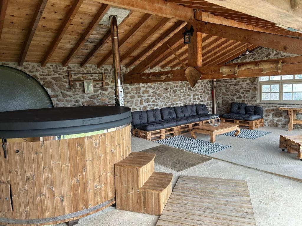 une chambre avec des canapés et un tonneau dans un bâtiment dans l'établissement La Petite Chavanne 4 étoiles, à Champdieu