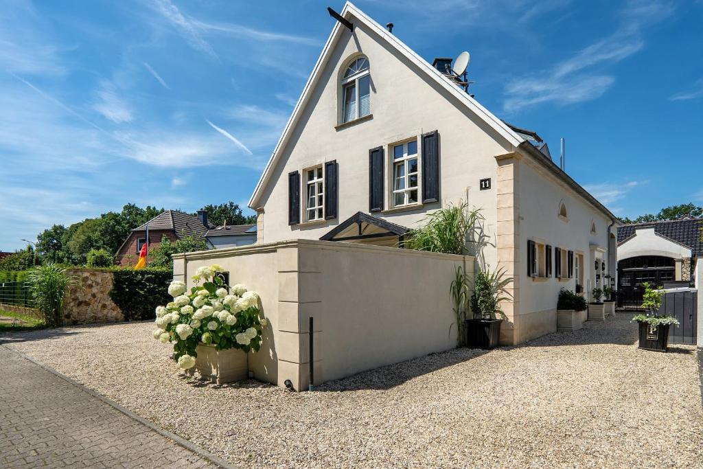 a large white house with a garage at Gästewohnung am See in Neuenkirchen