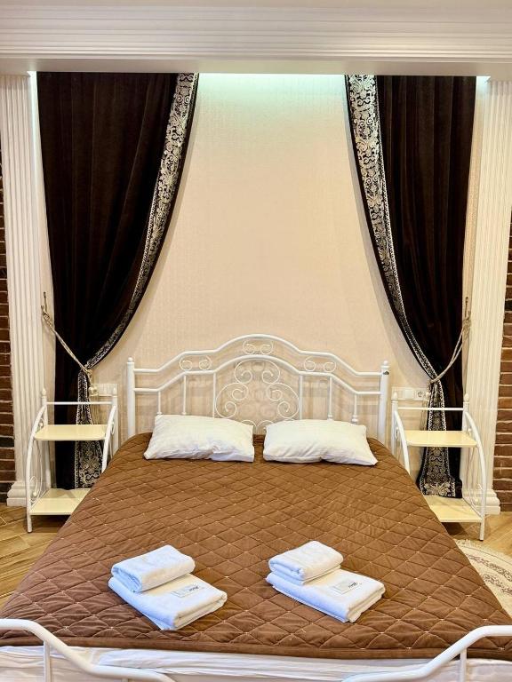 a bedroom with a bed with two towels on it at Lavender Night Apartments in Chernivtsi