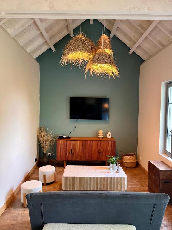 un salon avec un canapé et une télévision à écran plat dans l'établissement Belle maison Ville medieval Gourdon, à Gourdon