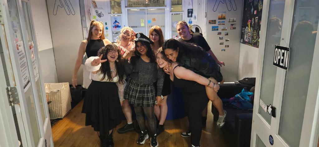 a group of women posing for a picture in a room at Astor Victoria Hostel in London