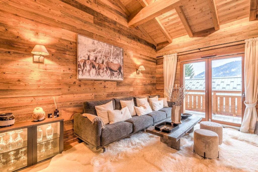 un salon avec un canapé et une grande fenêtre dans l'établissement Appartement Mady - Welkeys, à Megève