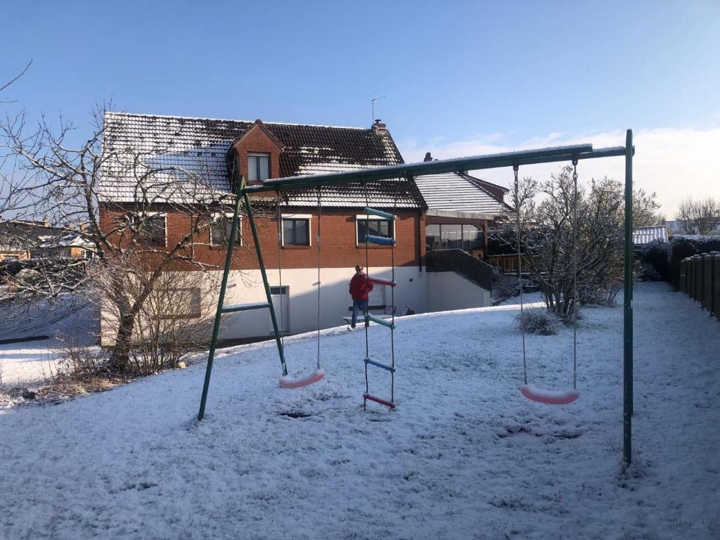 une personne sur une balançoire dans la neige dans l'établissement Appartement Belle Dune, à Bray-Dunes