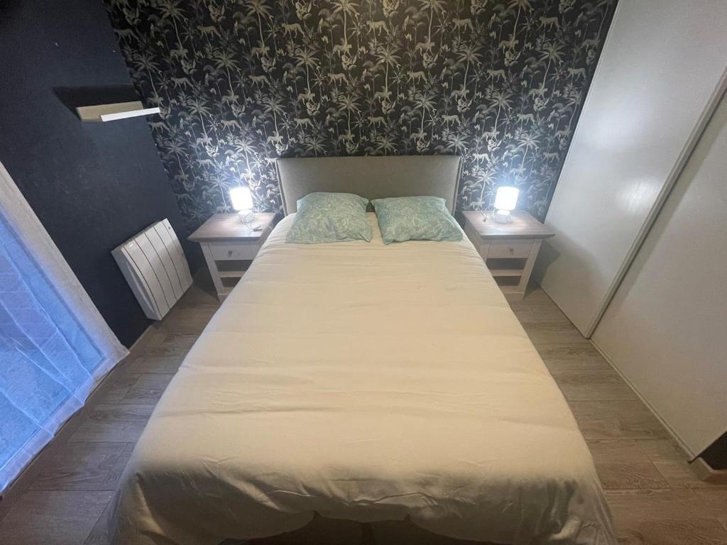 une chambre avec un grand lit avec deux tables de nuit dans l'établissement Lappart, à Seyssel