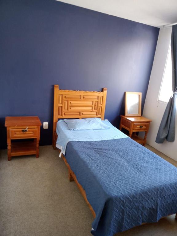 a blue bedroom with a bed and two night stands at Fresnos 14 Queretaro in Mendiola