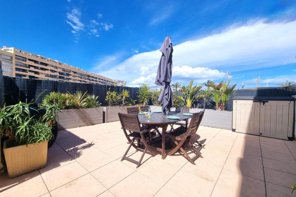 une table et des chaises avec un parasol sur une terrasse dans l'établissement Le Christina - Terrasse - Parking - WIFI, à Saint-Cyprien