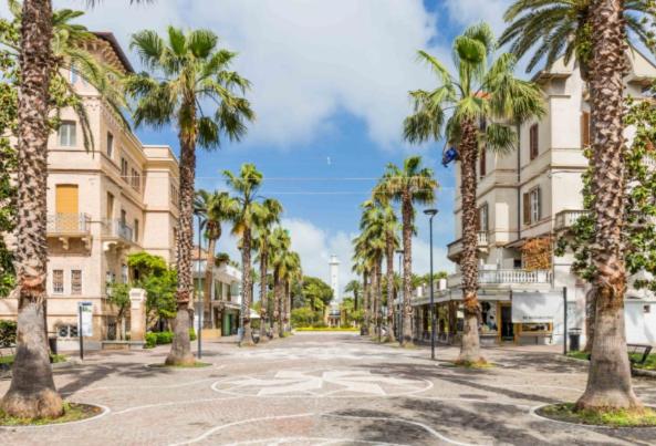 una strada vuota con palme ed edifici di Villa Francesca Luxury a Grottammare