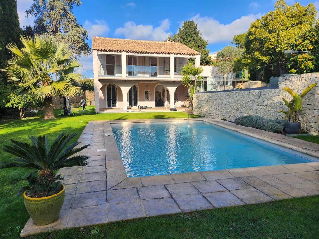 une maison avec une piscine devant une maison dans l'établissement Villa Miliana, au Cannet