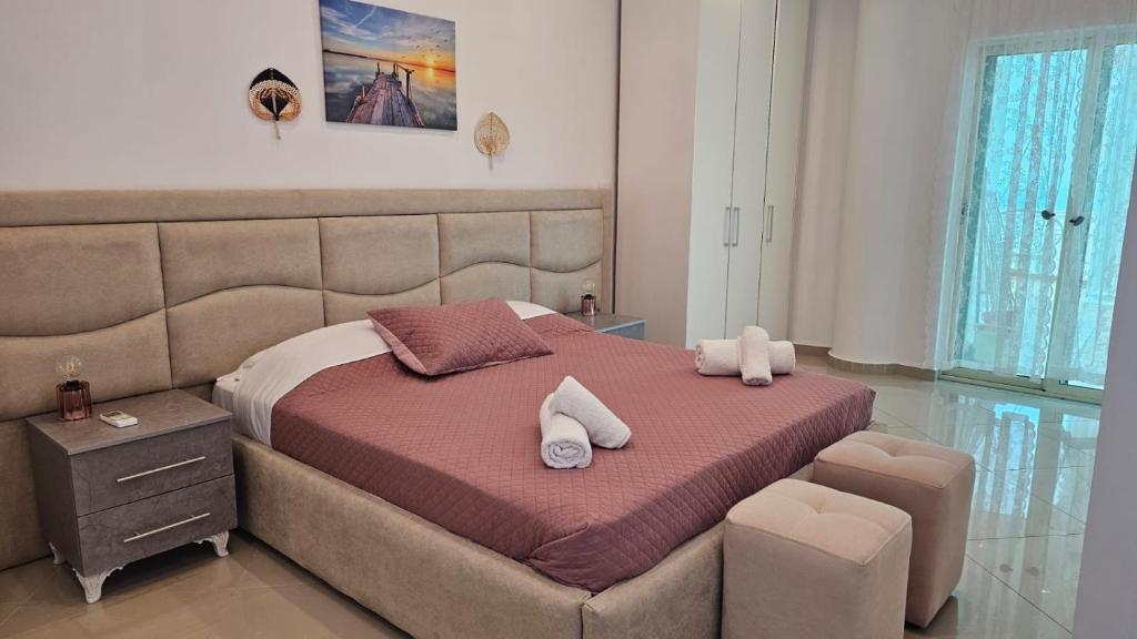 een slaapkamer met een groot bed en 2 handdoeken bij Seaside Jon Saranda in Sarandë