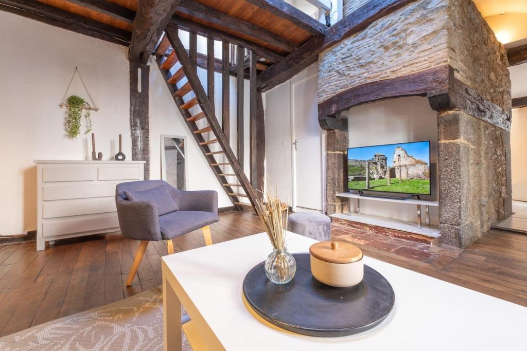 - un salon avec un mur en briques et une télévision dans l'établissement Charmant Duplex Coeur Historique, à Rennes