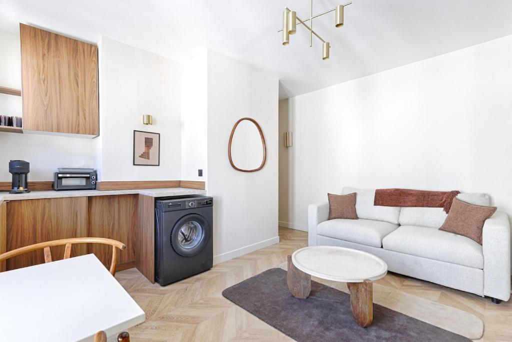 un salon avec un canapé et une table dans l'établissement Barbès Buttes Chaumont Cosy Studio 2P, à Paris