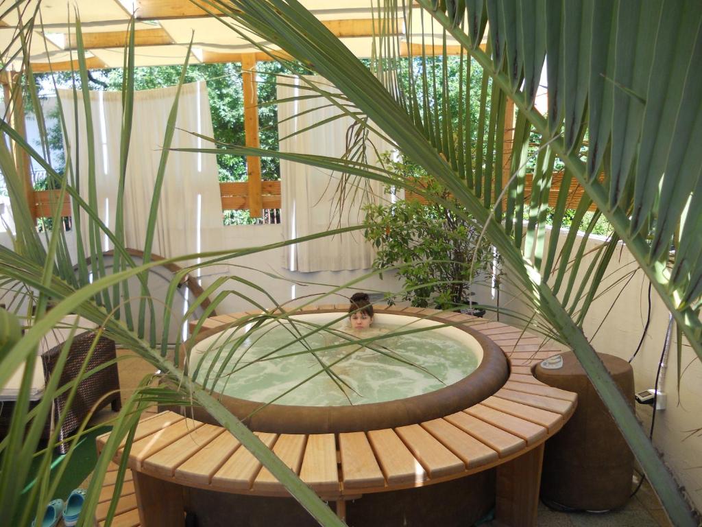 bañera de hidromasaje de madera en una habitación con plantas en Apartment Teuta, en Zadar
