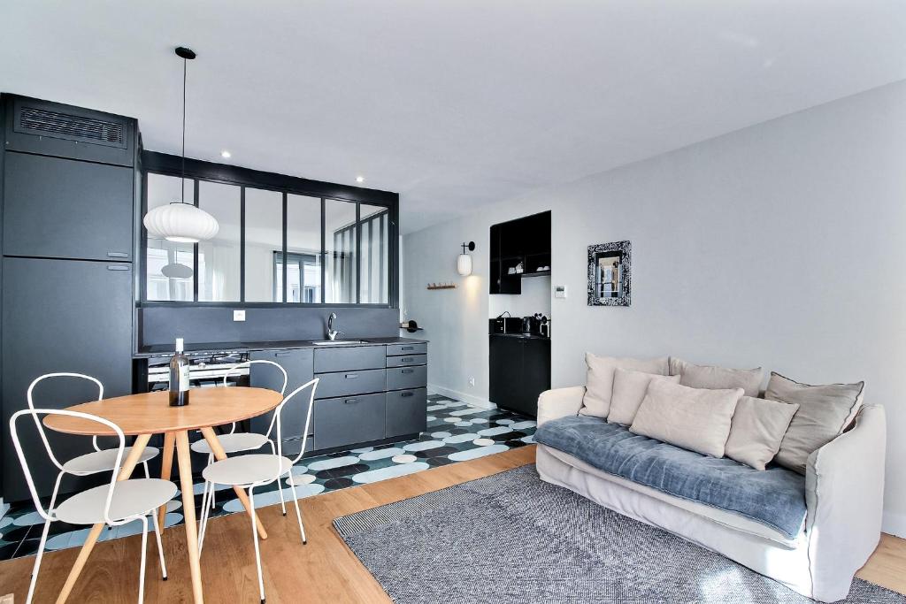 un salon avec une table et un canapé dans l'établissement PARISIAN HOME l MONTORGUEIL, à Paris