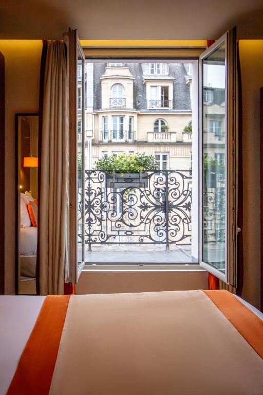 a bedroom with a bed and a large window at Hôtel La Bourdonnais by Inwood Hotels in Paris