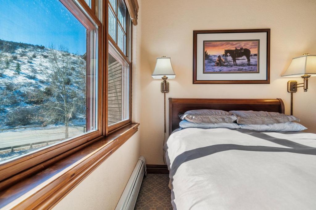 Un dormitorio con una cama y una ventana grande. en The Lodge at Brookside A Perfect Mountain Getaway, en Avon