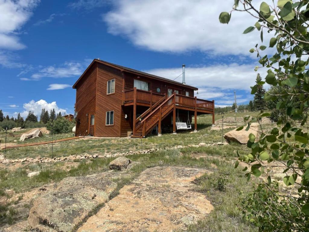 una gran casa de madera en una colina en un campo en Stunning Secluded Mtn Getaway, Picturesque Views, en Bordenville