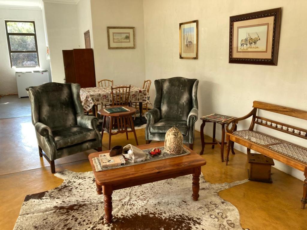 a living room with chairs and a coffee table at Kareepoort Guest Farm in Bloemfontein