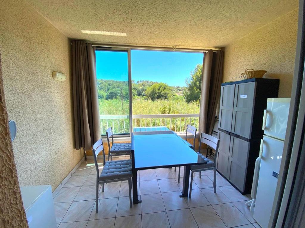 une cuisine avec une table et des chaises ainsi qu'une grande fenêtre dans l'établissement Studio - Gare - Centre ville, à Sanary-sur-Mer