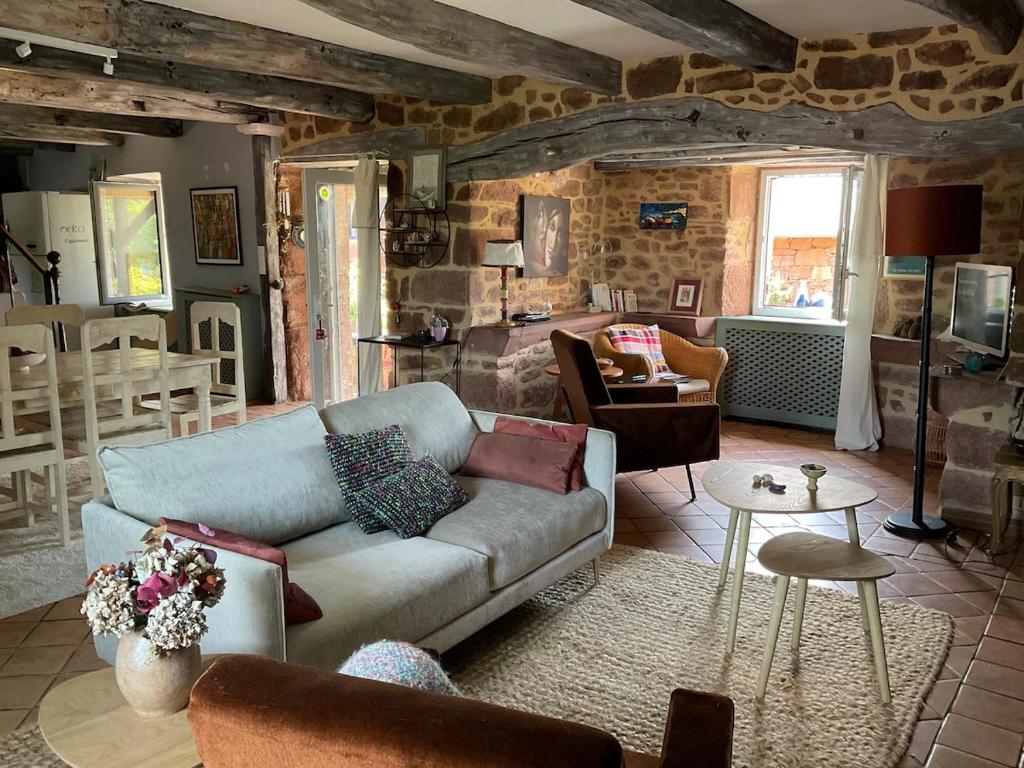 un salon avec un canapé et une table dans l'établissement Maison pleine de charme située sur une zone touristique, à Saint-Christophe-Vallon