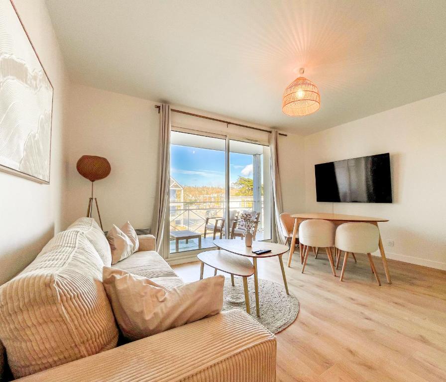 プルゴンヴランにあるAppartement Cosy, terrasse vu mer, piscine, Sauna - WarmHouseのソファとテーブルのあるリビングルーム