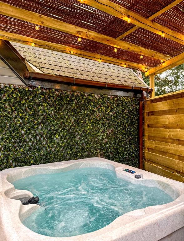 a jacuzzi tub in a backyard with a wall at Danu 1A -Hot Tub-Perth-Pet Friendly-Luxury-Romantic in Perth