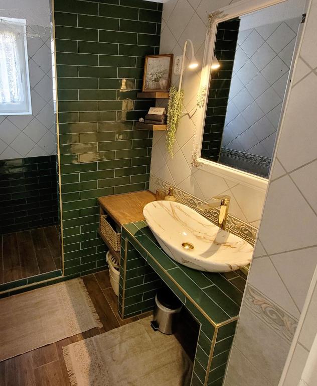 a bathroom with a sink and a mirror at Bonjour Vendégház in Nyíregyháza