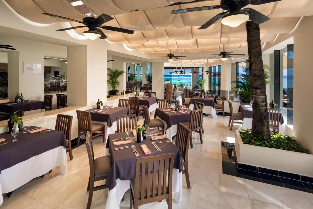 a dining room with tables and chairs in a restaurant at Grand Oasis Tulum Riviera - All Inclusive in Akumal