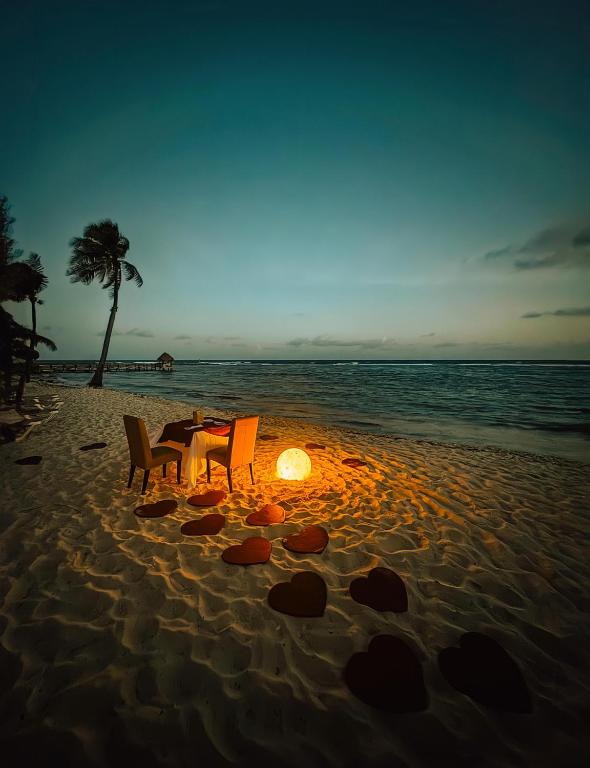a table and chairs on the beach at sunset at Grand Oasis Tulum Riviera - All Inclusive in Akumal