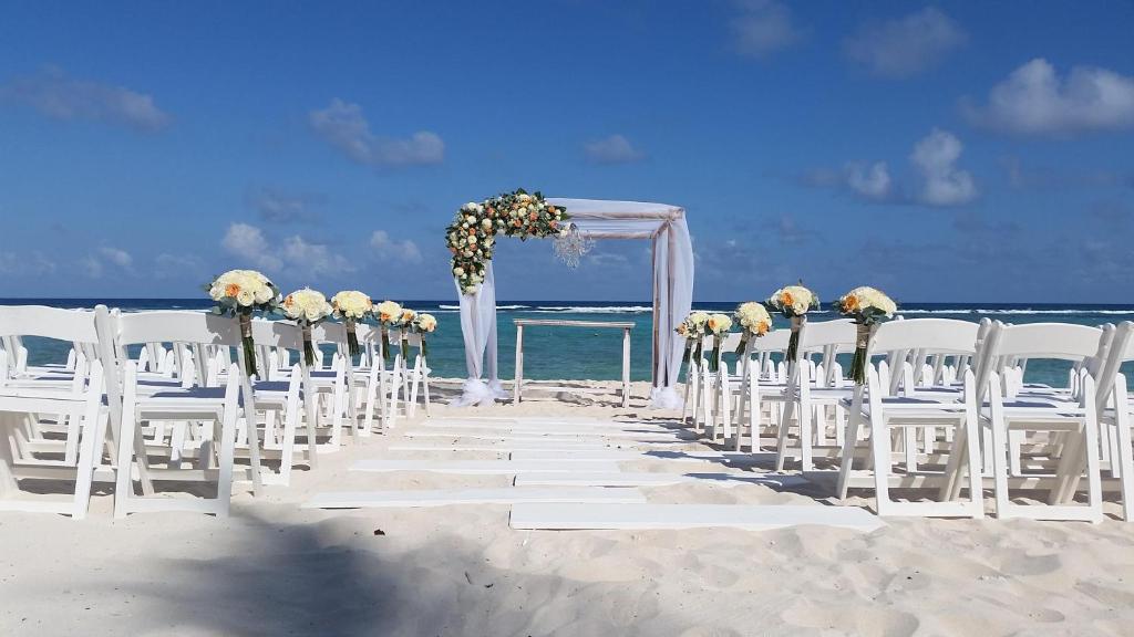 a wedding ceremony on the beach with white chairs at Grand Oasis Tulum Riviera - All Inclusive in Akumal