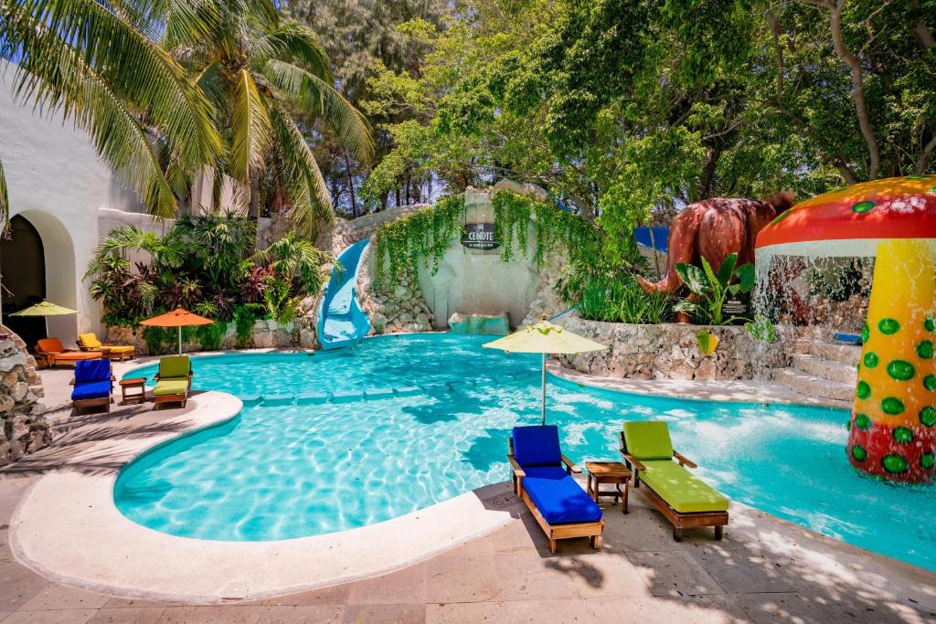 Children's pool area with colorful inflatable decorations and loungers under palm trees.