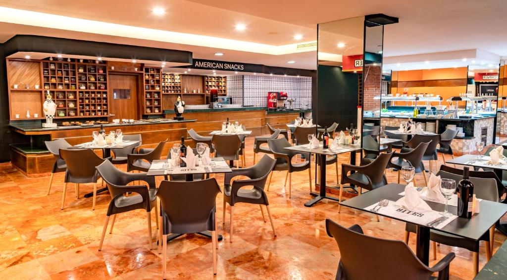 Dining room with round tables, black chairs, and wooden counter with American snacks sign.