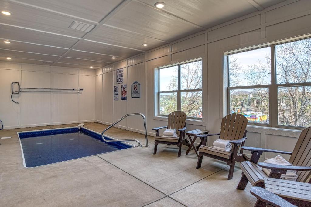 a pool room with chairs and a swimming pool at Blue Bear Splash in Pigeon Forge
