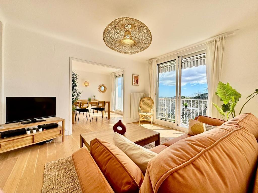 un salon avec un canapé et une télévision dans l'établissement Le Cocon Méditerranéen, à Béziers