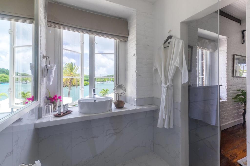 イングリッシュ・ハーバー・タウンにあるAdmiral's Inn and Gunpowder Suitesのバスルーム(バスタブ、シンク付)、窓が備わります。
