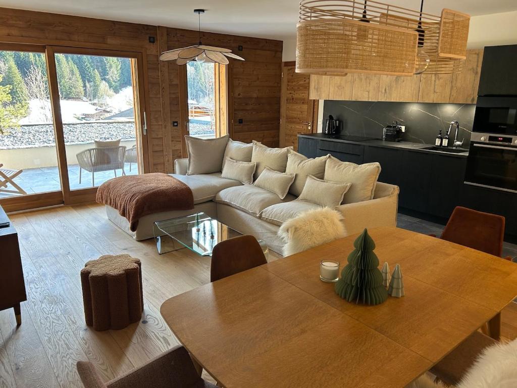 un salon avec un canapé et une table dans l'établissement Chalet Angelus - Appartement neuf 3 chambres Grand Bornand, à Saint-Jean-de-Sixt