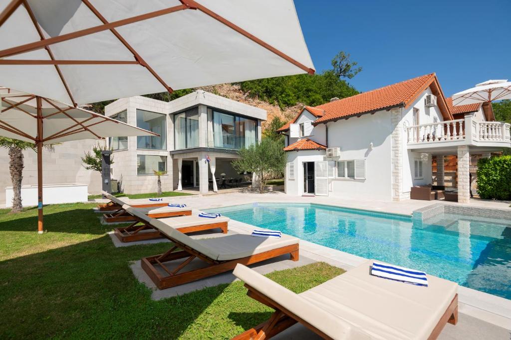 a villa with a swimming pool and a house at Luxury Villa Karmen with pool & spa zone in Ričice