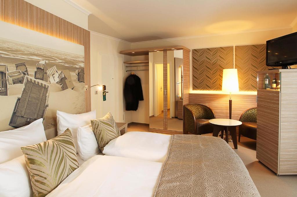 Postel nebo postele na pokoji v ubytování Strandhotel Duhnen