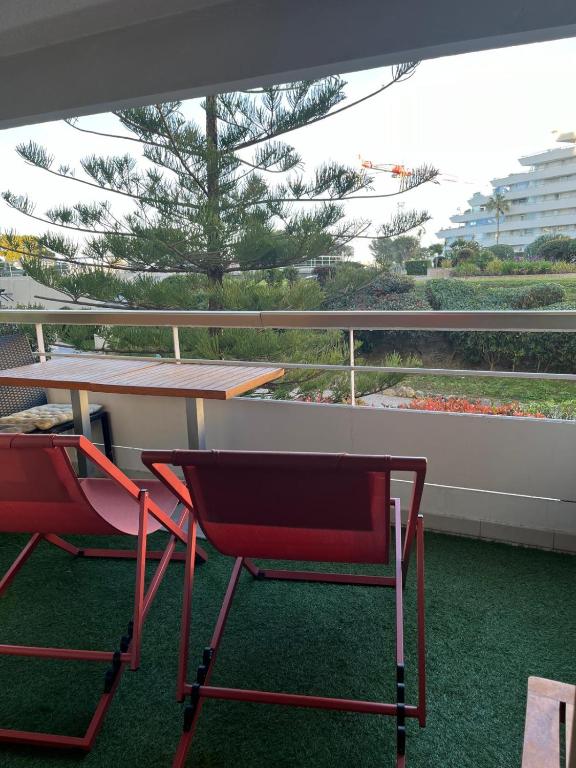 - deux chaises rouges et une table sur un balcon dans l'établissement 4 pers , 100m de la plage marina baie des anges French Riviera, à Villeneuve-Loubet