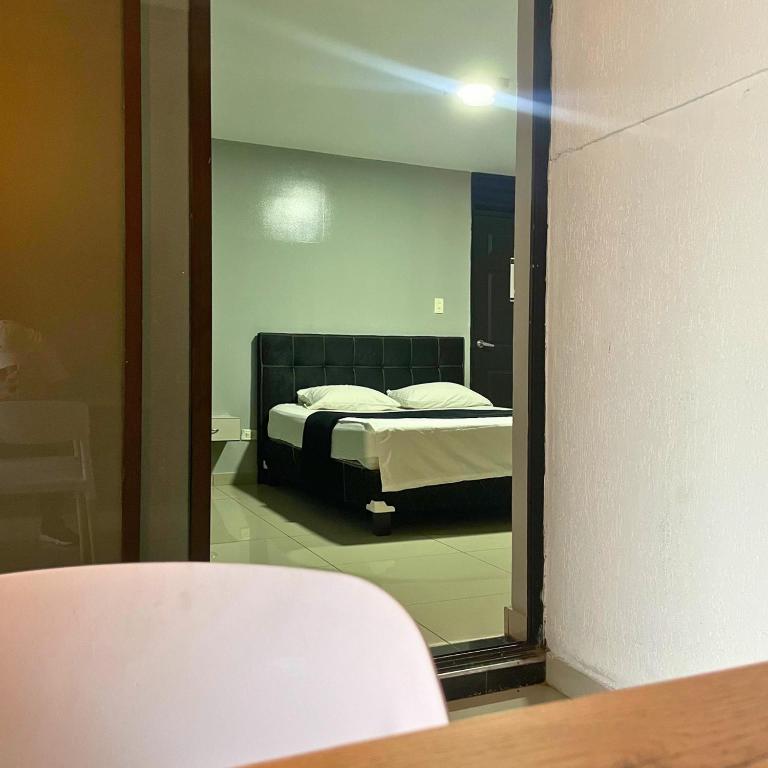 Postel nebo postele na pokoji v ubytování Hotel Escorial Ibagué